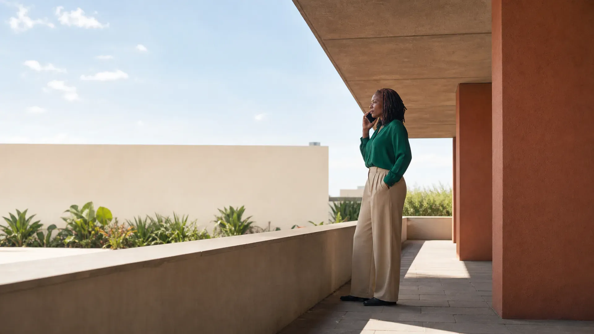 A professional taking a phone call on a sunlit terrace
