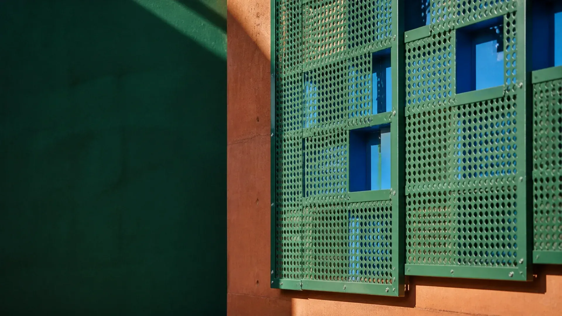 Screened openings filtering hard light into a shaded interior
