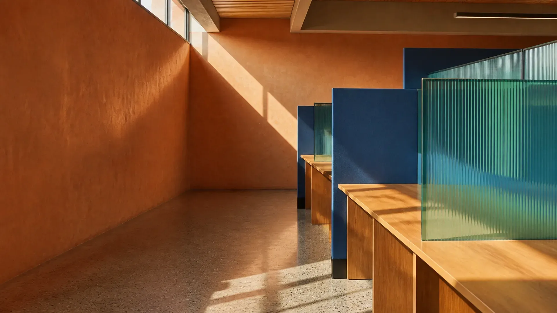 A sunlit operations floor with benches and teal dividers